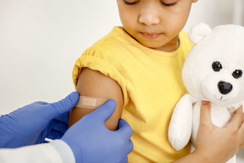 Doctor Putting Band-Aid on the Arm of Girl After Vaccine